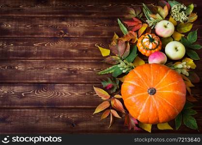 Rustic fall greeting card background with pumpkin, red green yellow leaves, apples, copy space