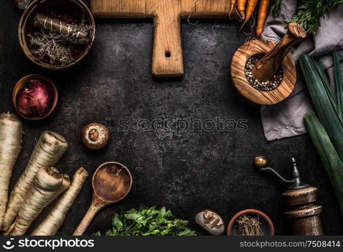 Rustic food background with root vegetables, herbs,spices ,leek and champignon mushrooms on dark rustic table with kitchen utensils, top view. Copy space. Vegetarian food. Healthy cooking and eating
