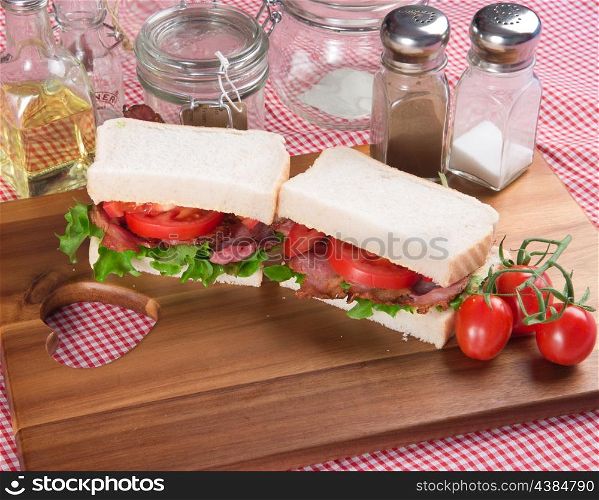 Rustic kitchen setting for fresh BLT on white sandwich
