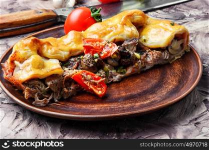 rustic meat pie. Cut pie with meat and mushrooms on the plate