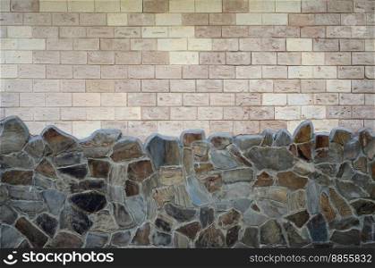 Rustic old beige white brick wall background and worn foundation with shabby brown stones. Rustic old beige white brick wall background