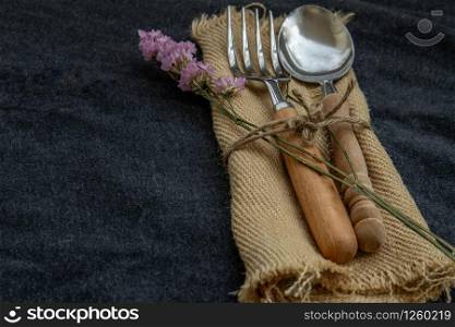 Rustic vintage set of wooden spoon and fork on black background. Copy space, Selective focus.
