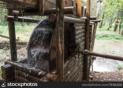 Rustic watermill with wheel being turned by force of falling water from Altai mountain river.. Rustic watermill with wheel
