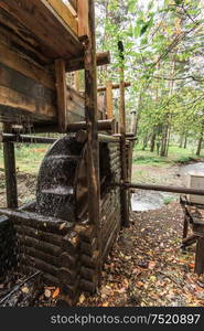 Rustic watermill with wheel being turned by force of falling water from Altai mountain river.. Rustic watermill with wheel