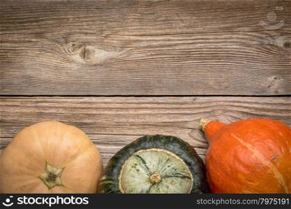 rustic weathered wood background with winter squash (Thelma Sanders, buttercup and hubbard)