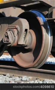 rusty and polished freight train wheel on railroad track
