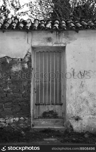 Rusty door and textured wall. Abandoned house exterior.