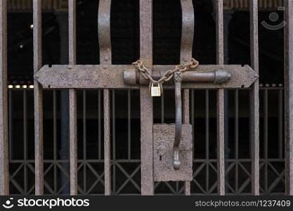 rusty lock with a padlock closing a gate