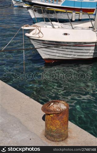 rusty metal mooring bollard at Pserimos docks, Greece