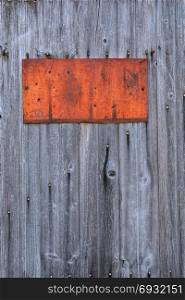 Rusty metal sign on wooden wall, copy space.
