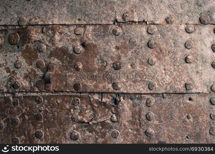 Rusty metal texture. Studded iron plate. Rivets on old rusty metal door. Weathered aged grunge texture.