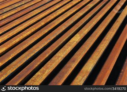 Rusty rails lined-up close as background perspective