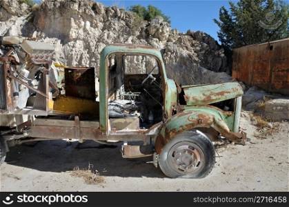 Rusty vintage vehicle and industrial machinery at a quarry.