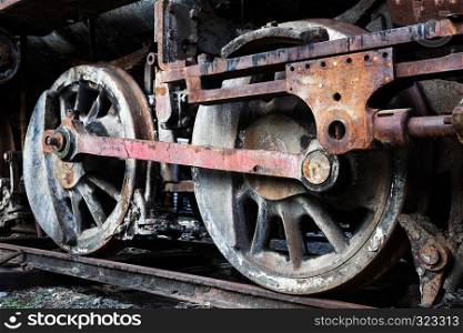 rusty wheels of old steam locomotive close up
