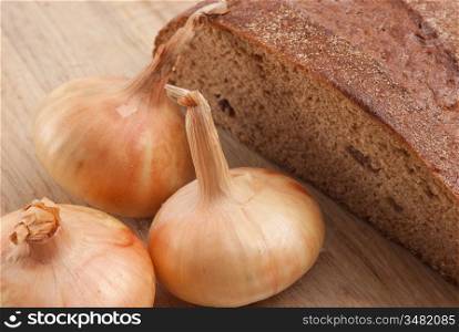 rye bread and onions on a cutting board isolated on white