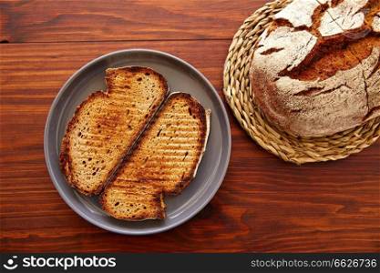 Rye bread toasted slices on dark wooden table top view