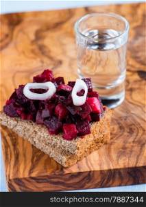 Rye bread with beetroot salad and shot of vodka, selective focus
