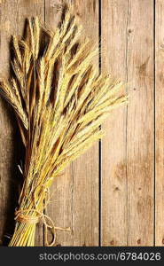 Rye spikelets on wooden background