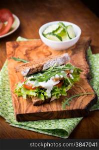 Rye toast sandwich with green leaf, tomato and chicken, selective focus