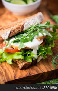 Rye toast sandwich with green leaf, tomato and chicken, selective focus