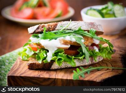 Rye toast sandwich with green leaf, tomato and chicken, selective focus