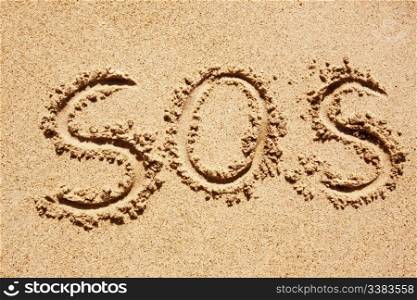 S.O.S written in the sand with a finger or stick