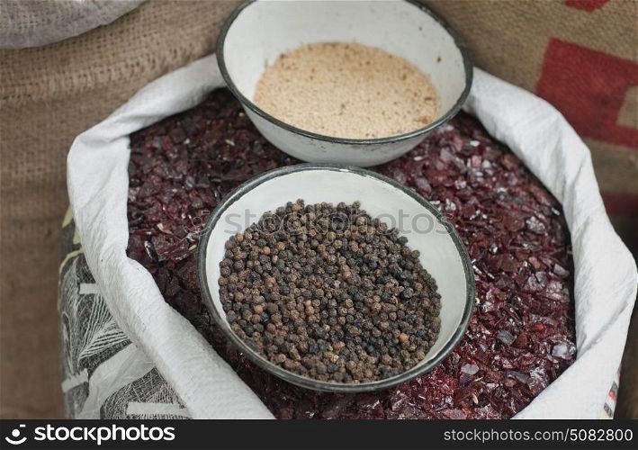 Sack of black salt with black pepper and sesame seeds in bowl for sale at the market