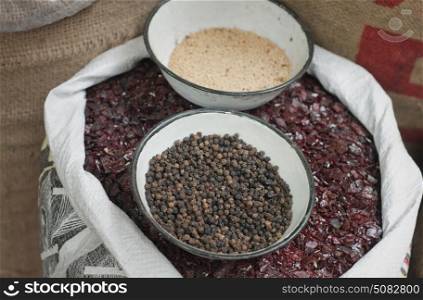 Sack of black salt with black pepper and sesame seeds in bowl for sale at the market