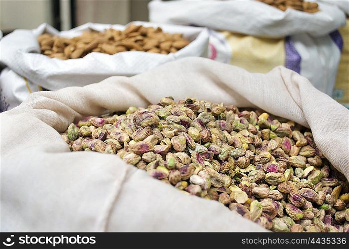 Sack of pistachio nuts and almond for sale at market,India.