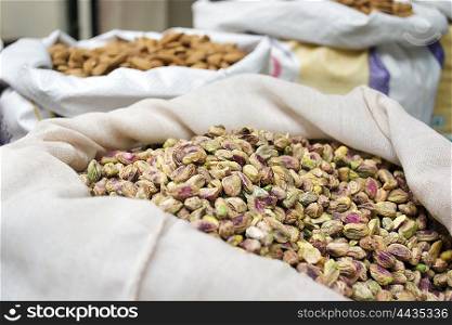 Sack of pistachio nuts and almond for sale at market,India.