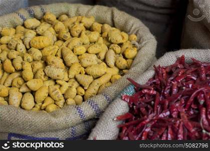 Sacks of dried chillies and turmeric root for sale at the market