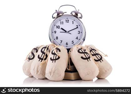 Sacks of money and alarm clock on white
