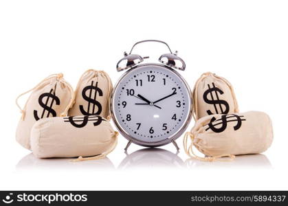 Sacks of money and alarm clock on white