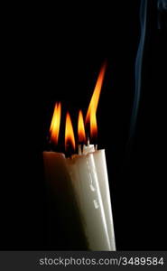 sacred candles in dark on black background