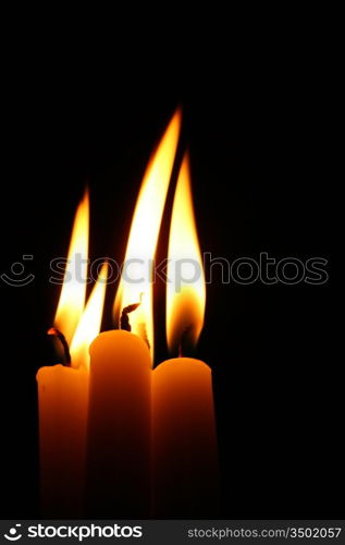 sacred candles in dark on black background