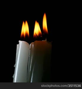 sacred candles in dark on black background