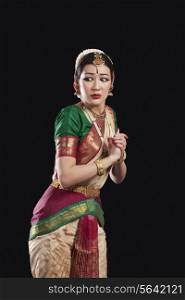 Sacred woman performing classical dance on black background