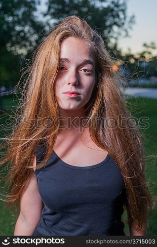 Sad 20s female outside close-up image. Portrait of a beautiful young 20s women in the park in evening.
