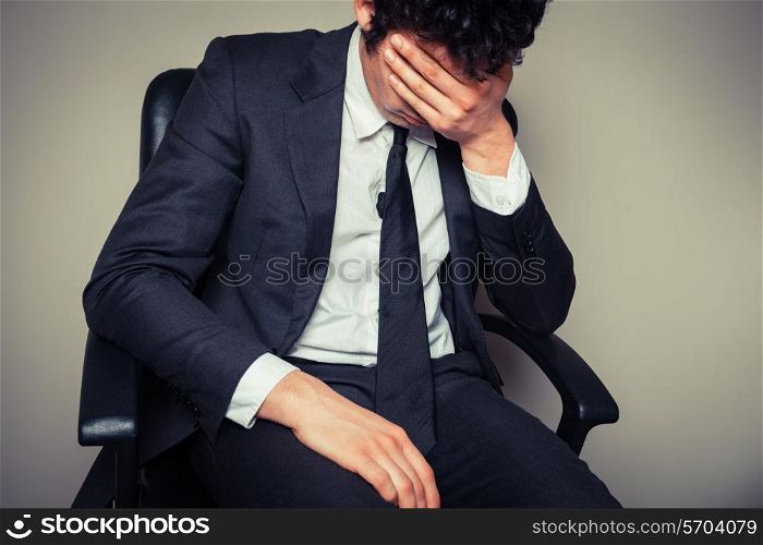 Sad and tired businessman is sitting in an office chair