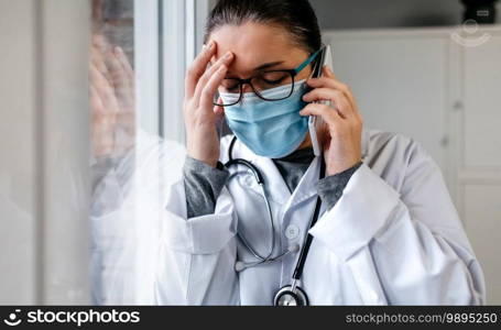 Sad and worried female doctor talking on the phone