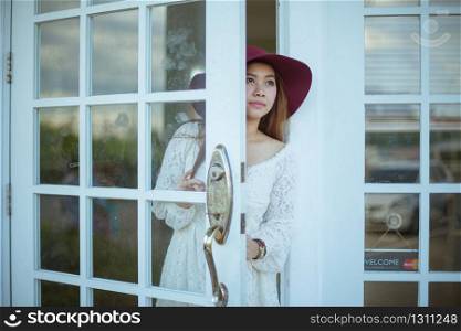 Sad asian vintage woman looking out the door