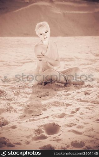 sad beautiful girl in the desert on a background of sand. vintage