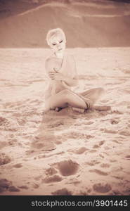 sad beautiful girl in the desert on a background of sand. vintage
