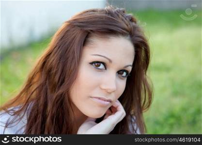 Sad brunette woman in park thinking looking at camera