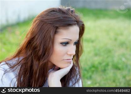 Sad brunette woman in park thinking something
