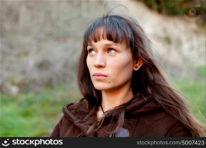 Sad brunette woman with blue eyes in the park