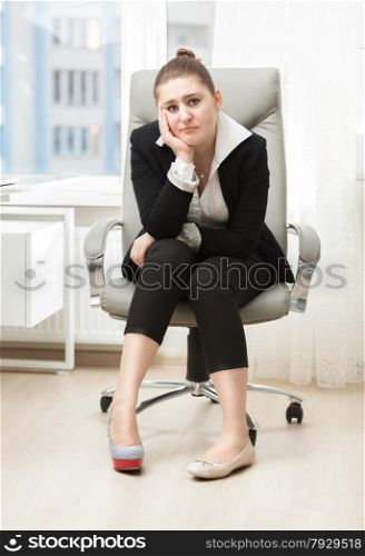 Sad businesswoman choosing between high heeled shoe and ballet flat