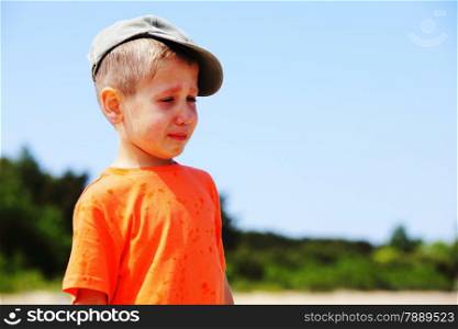Sad child. Portrait of crying unhappy little boy outdoor