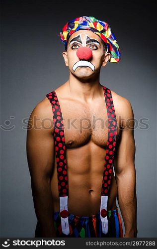 Sad clown against dark background