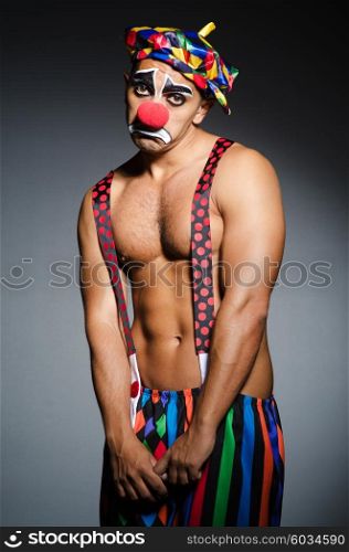 Sad clown against dark background